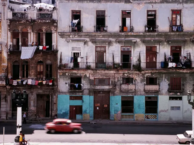 In this image in the center there are some buildings, clothes, railing, doors, windows. And at the...