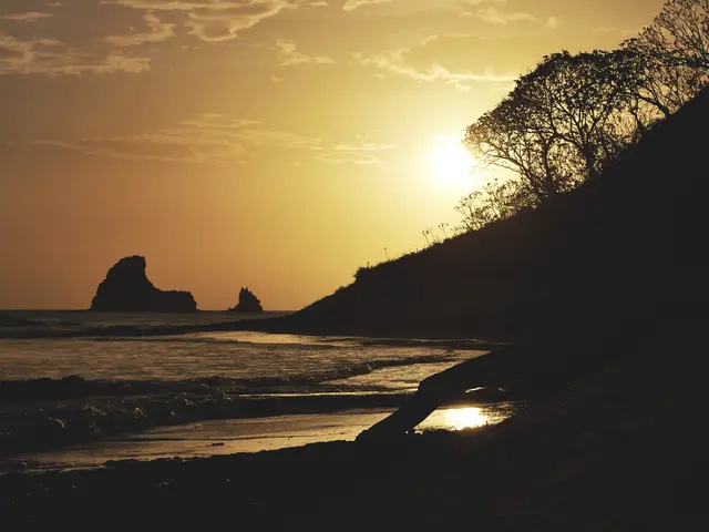In this image there is a beach and at the bottom it looks like there is sand, and in the background...